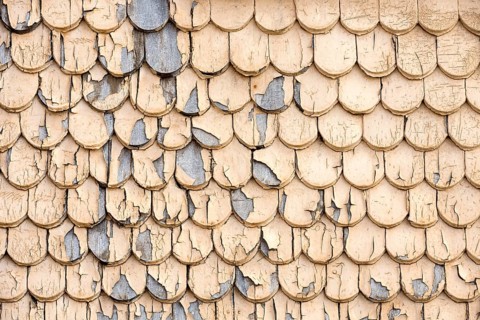 pattern of old wooden shingles with peeling paint