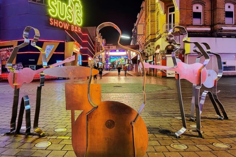 Beatles metal figures on Beatles Square at night