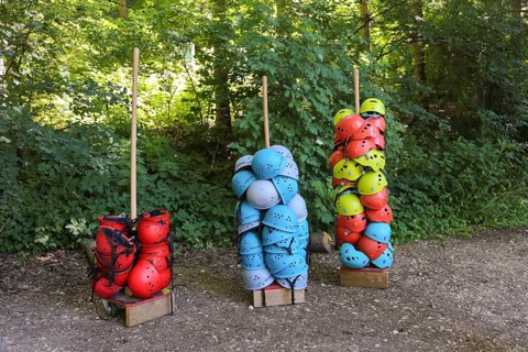 Many stacked helmets in the forest ropes course