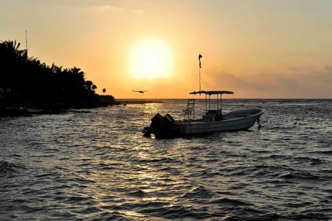 Sunset with boat at Playa del Carmen