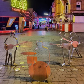 Beatles metal figures on Beatles Square at night
