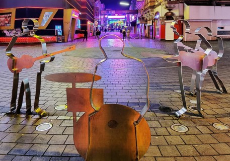 Beatles metal figures on Beatles Square at night