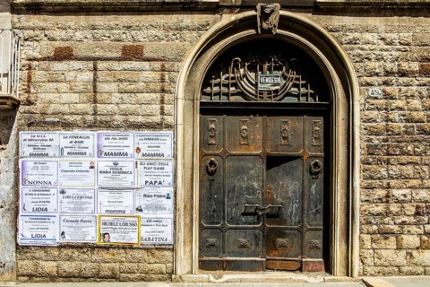 Obituaries on house wall