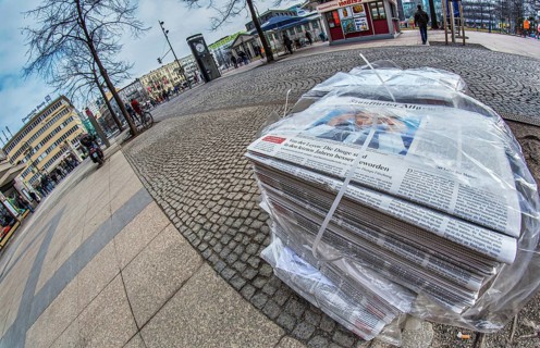 Piles of daily newspapers on the pavement
