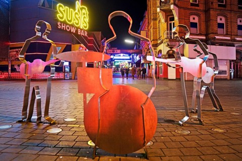 Beatles metal figures on Beatles Square at night