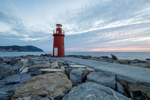 Sunrise with lighthouse at the harbour pier in Porto Maurizio