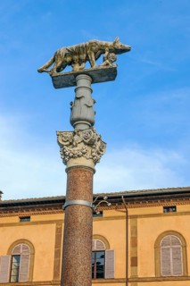 Column with Corinthian column capital on forecourt of Siena Cathedral with Capitoline she-wolf suckling brothers Romus and Remulus