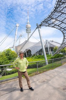 Friendly smiling man at the Olympic tower with Olympic tent roof