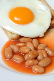 White beans with tomato sauce and fried egg on toast