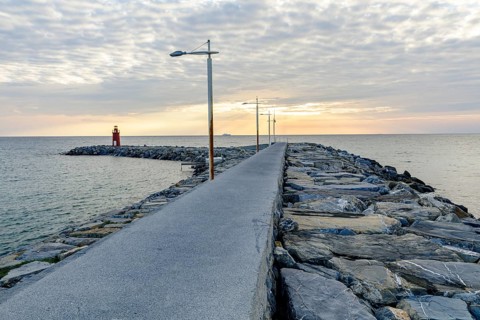 Sunrise with lighthouse at the harbour pier in Porto Maurizio