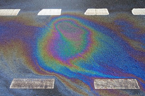 Environmentally harmful traces of oil on an asphalt road