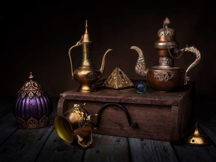 Still life with oriental jug and gilded pyramid on wooden box