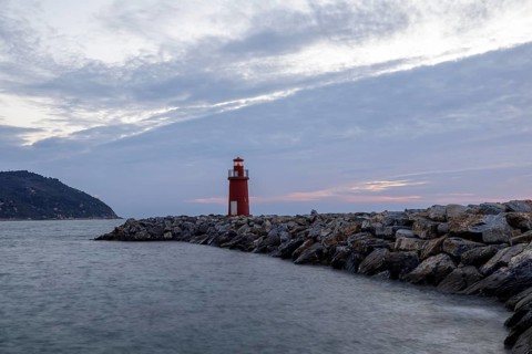 Sunrise with lighthouse at the harbour pier in Porto Maurizio