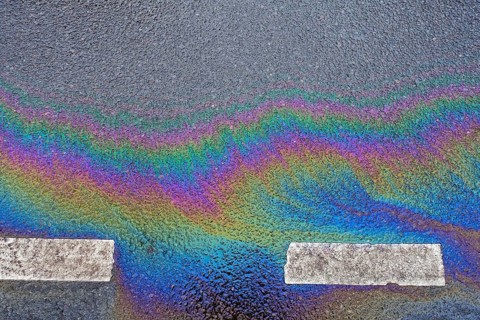 Environmentally harmful traces of oil on an asphalt road