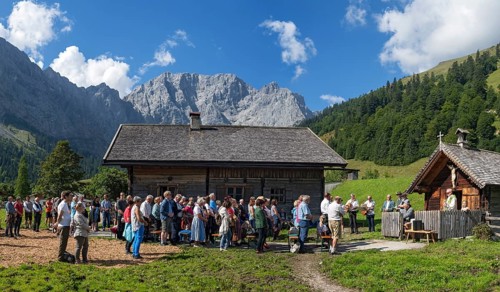 Mass celebration on Almkirtag in front of the wooden chapel in the alpine village of Eng