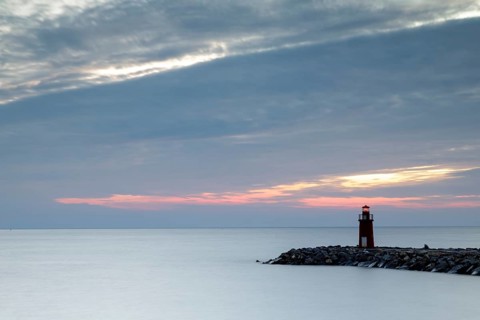 Sunrise with lighthouse at the harbour pier in Porto Maurizio