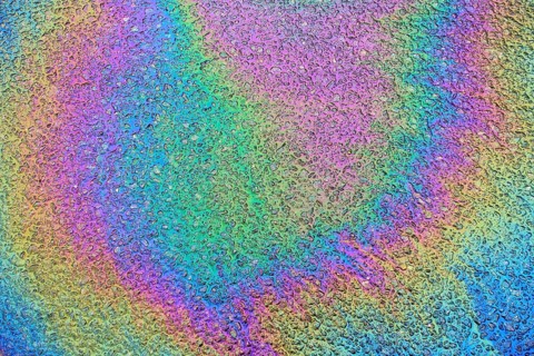 Environmentally harmful traces of oil on an asphalt road