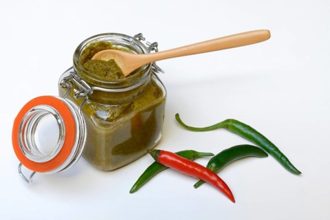 Green Thai curry paste in jar and chillies