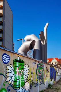 High-rise building with concrete balconies and ventilation pipes and wall with graffiti