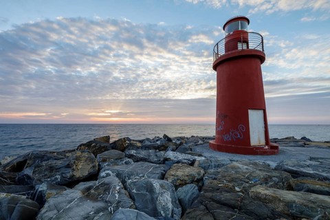 Sunrise with lighthouse at the harbour pier in Porto Maurizio