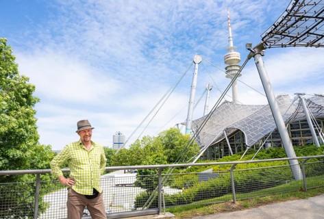 Friendly smiling man at the Olympic tower with Olympic tent roof
