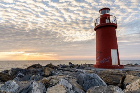 Sunrise with lighthouse at the harbour pier in Porto Maurizio