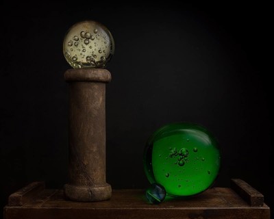 Still life with glass balls and wooden spool