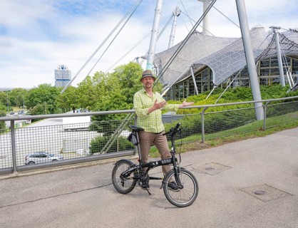 Man with bicycle on the Olympic tent roof