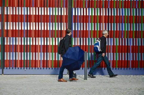Two men walking in front of the colourful striped facade of the Museum Brandhorst