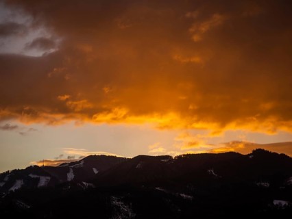 Clouds above the summit of the Mugel in the morning red at sunrise