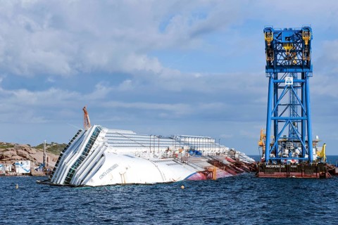 View of the bow of a capsized cruise ship with the name Costa Concordia visible
