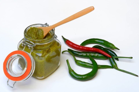 Green Thai curry paste in jar and chillies