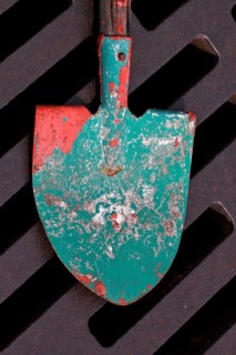 Shovel used to stir paint lies on drain grate of manhole