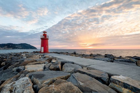 Sunrise with lighthouse at the harbour pier in Porto Maurizio