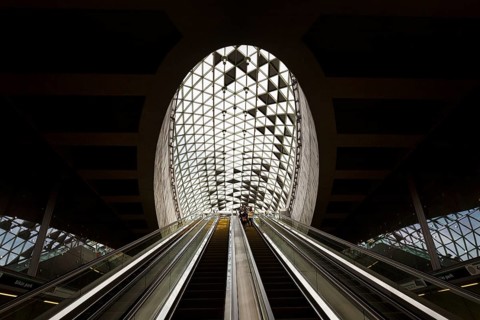 People on escalator with modern skylight