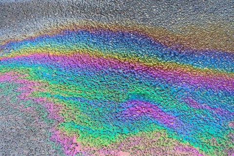 Environmentally harmful traces of oil on an asphalt road