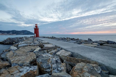 Sunrise with lighthouse at the harbour pier in Porto Maurizio
