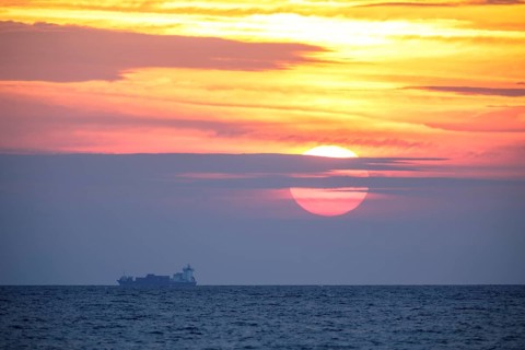 Sunrise with container ship on the Mediterranean Sea in Porto Maurizio