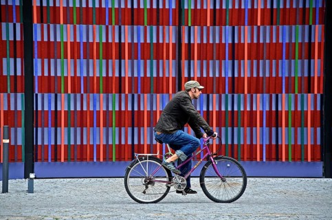 Cyclist in front of the colourful striped facade of the Brandhorst Museum