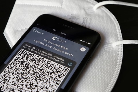 FFP2 mask and iPhone with Corona warning app with QR code for certificate of recovery