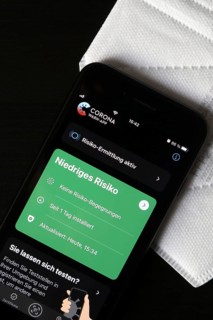 FFP2 mask and iPhone with low-risk Corona warning app