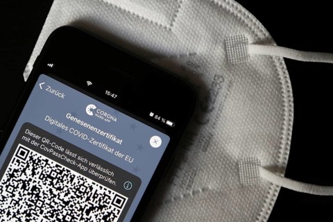 FFP2 mask and iPhone with Corona warning app with QR code for certificate of recovery