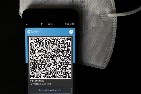 FFP2 mask and iPhone with Corona warning app with QR code for vaccination certificate