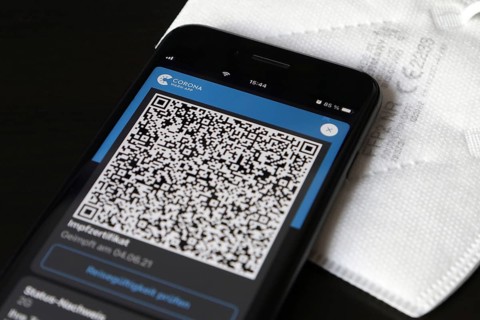 FFP2 mask and iPhone with Corona warning app with QR code for vaccination certificate