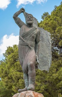 Statue and monument of Spyros Kayales with Greek flag
