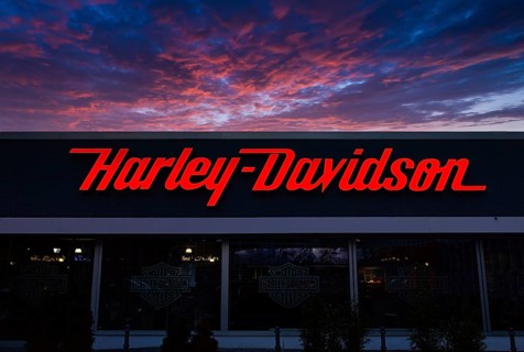 Illuminated Harley Davidson advertising sign at dusk