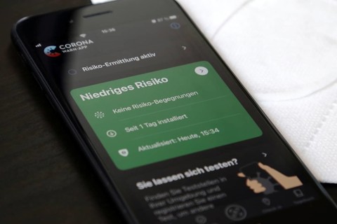 FFP2 mask and iPhone with low-risk Corona warning app
