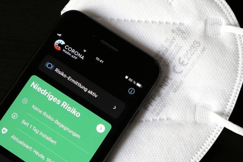 FFP2 mask and iPhone with low-risk Corona warning app