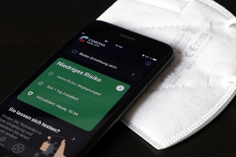 FFP2 mask and iPhone with low-risk Corona warning app