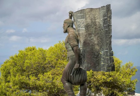 Statue and monument of Spyros Kayales with Greek flag